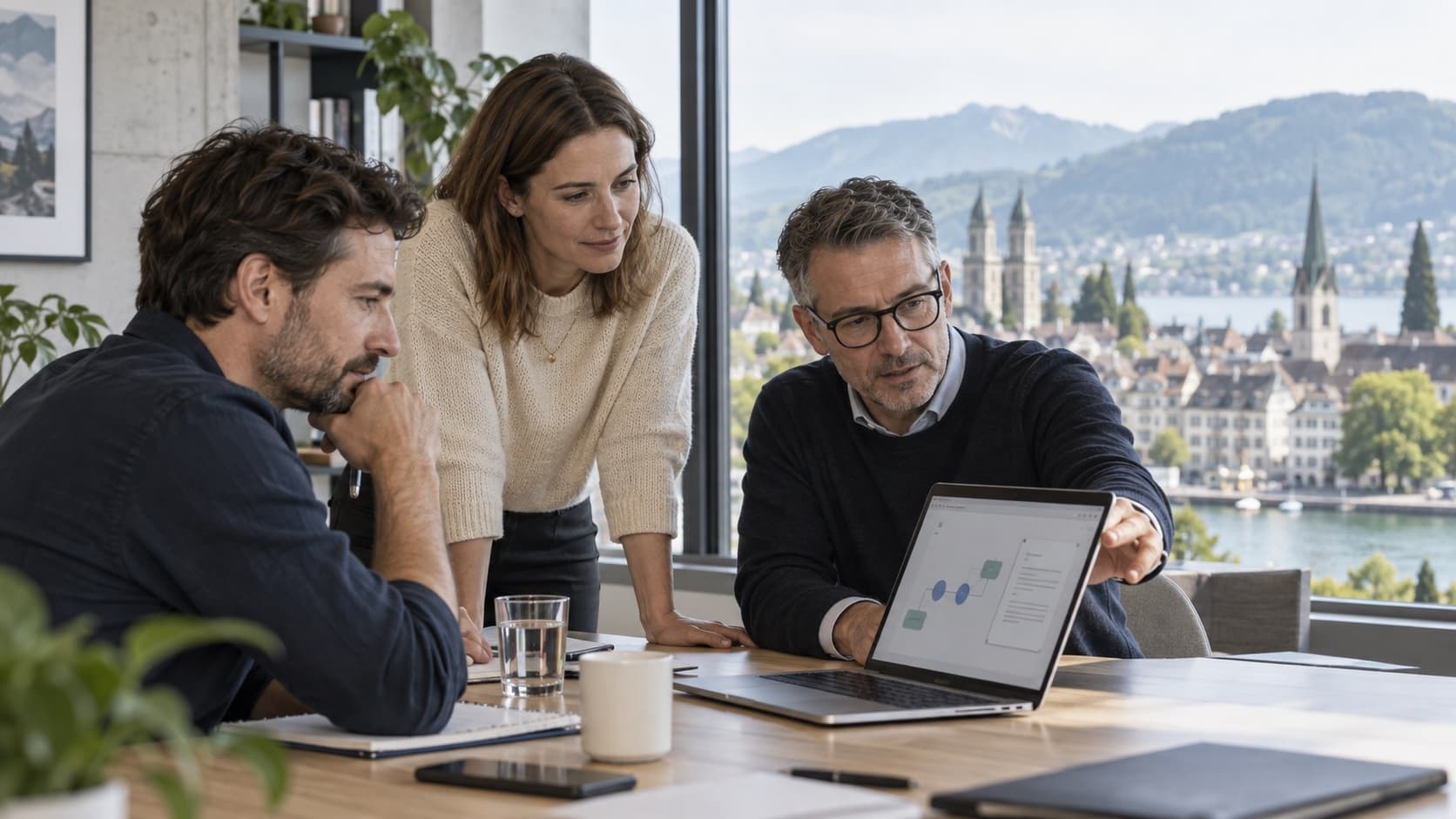 Drei Mitarbeitende besprechen an einem Laptop einen KI-Workflow, im Hintergrund Zürich mit See und Bergen